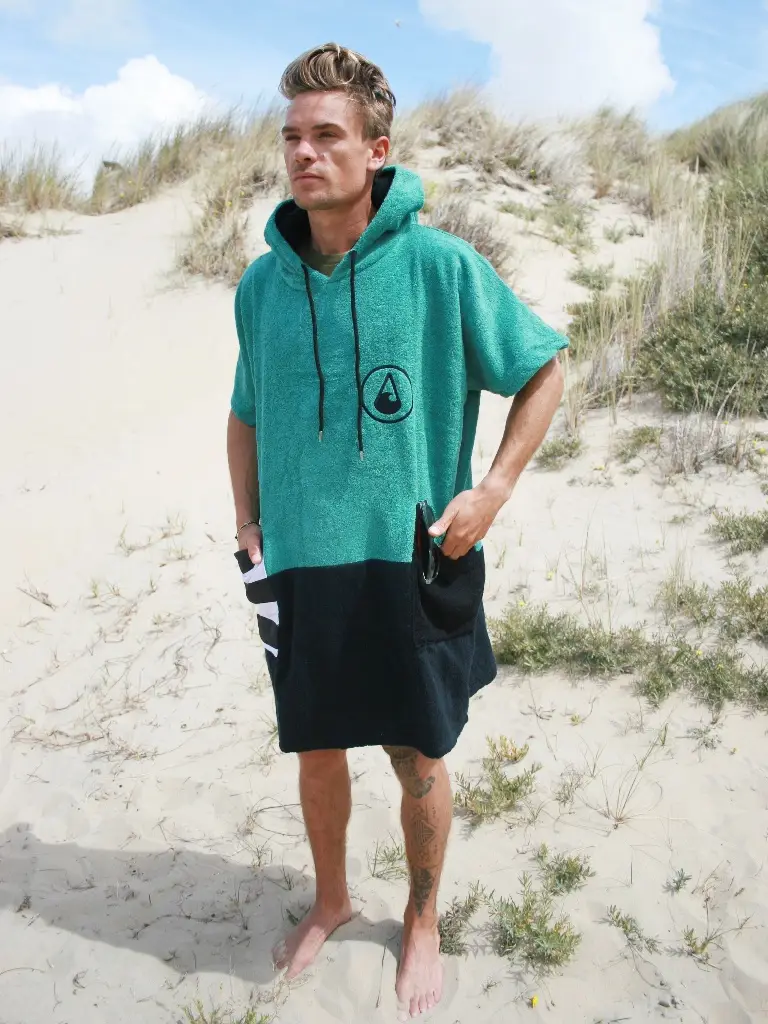 Barbat care poarta pe plaja un poncho barbati din bumbac, culoare verde cu negru