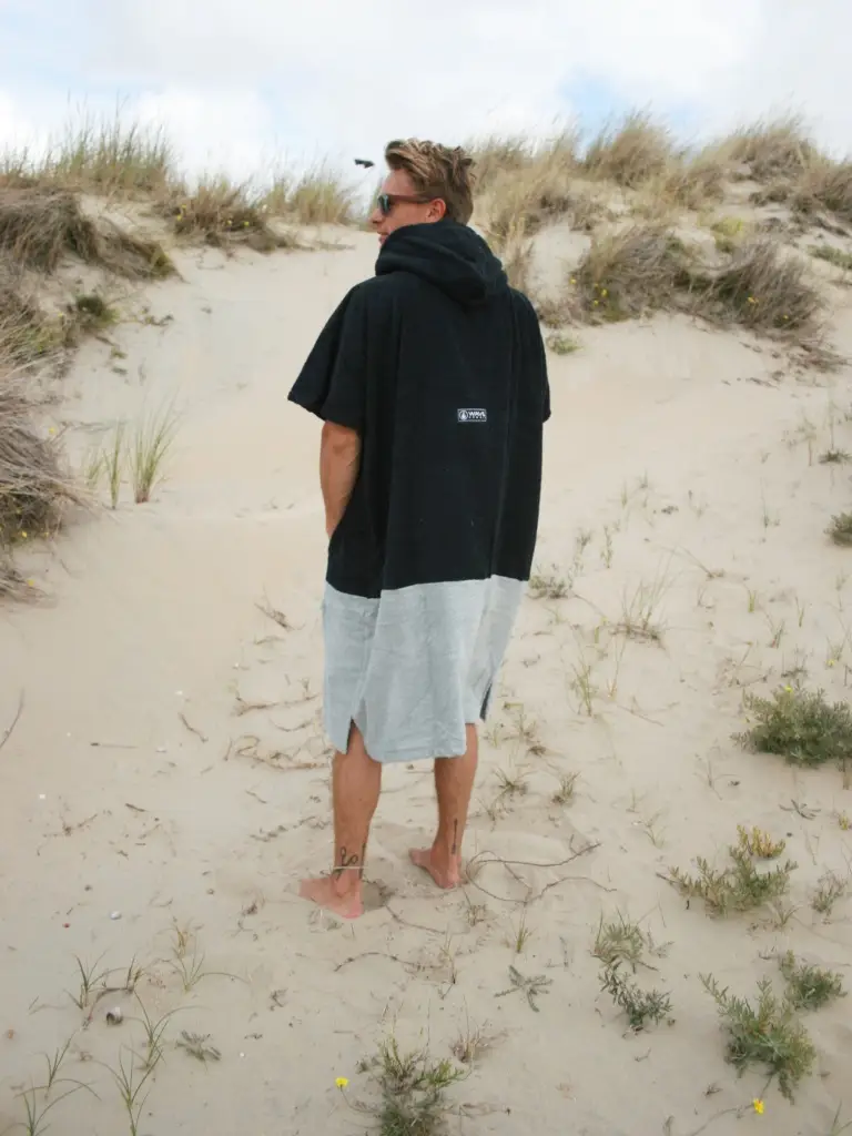 Barbat care poarta pe plaja un poncho barbati din bumbac, culoare negru cu gri