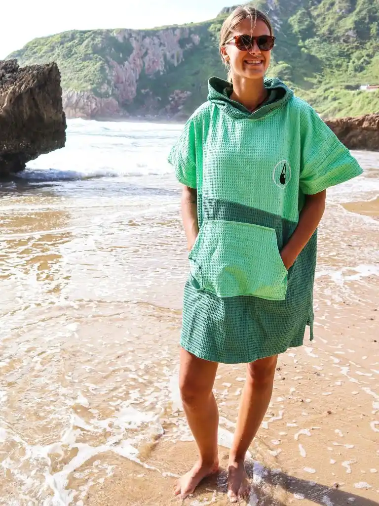 Femeie cu mainile in buzunar care poarta un poncho plaja dama colorat, pentru plaja, scuba sau surfing, culoare verde deschis si verde inchis