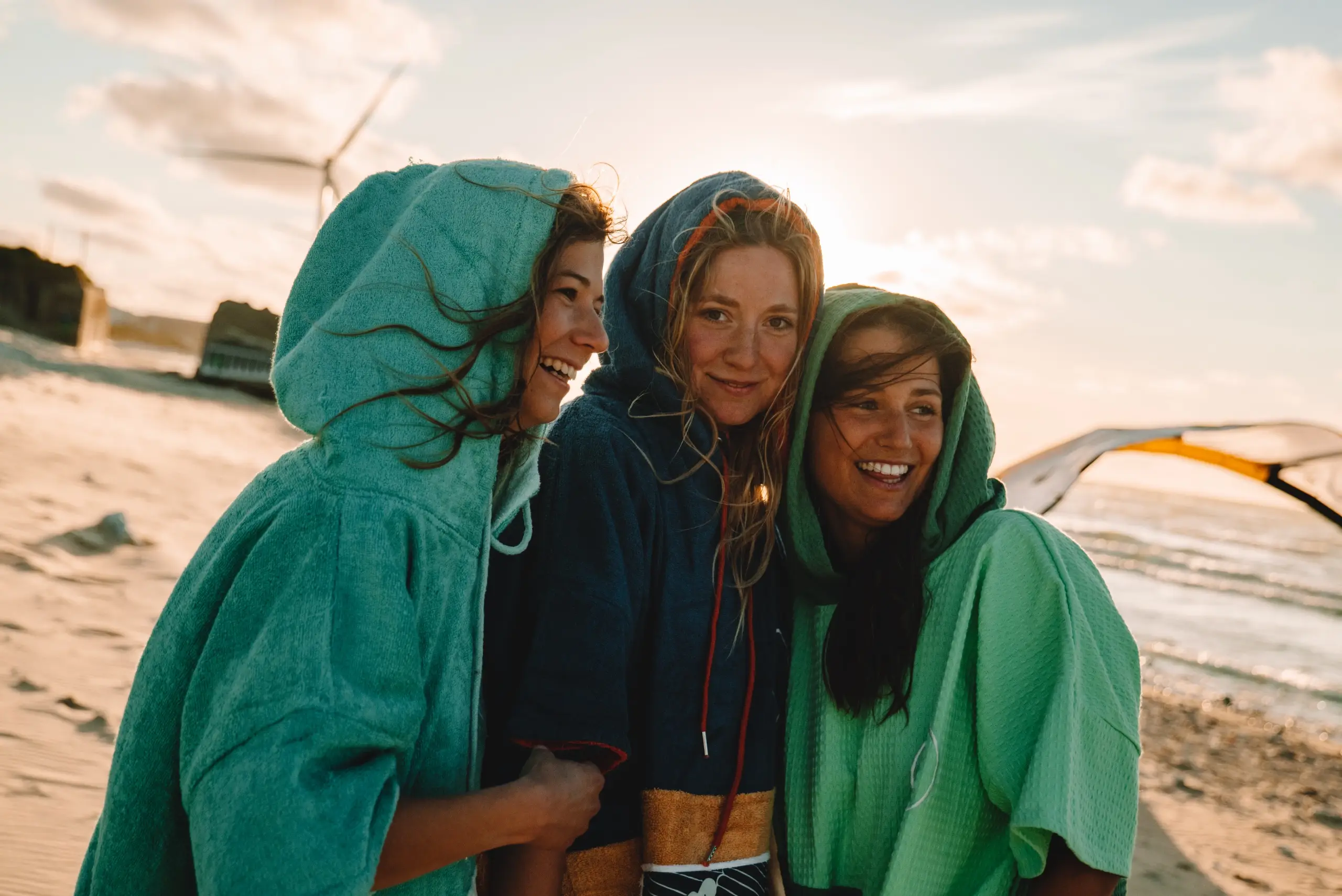 Trei fete care poarta haine plajă - poncho-uri de plaja colorate, culoare verde, albastru si crem